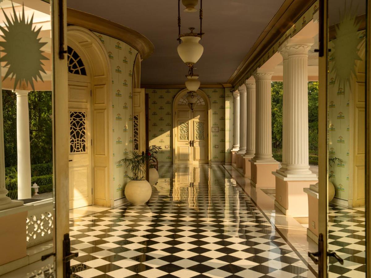 a hallway with a checkerboard floor and columns at Rajmahal Palace RAAS in Jaipur