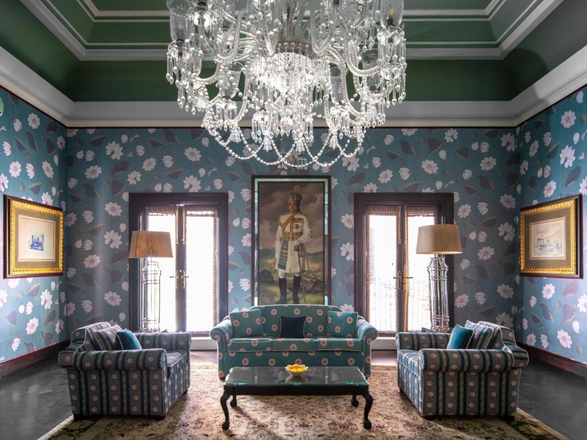 a living room with a chandelier and blue walls at Rajmahal Palace RAAS in Jaipur