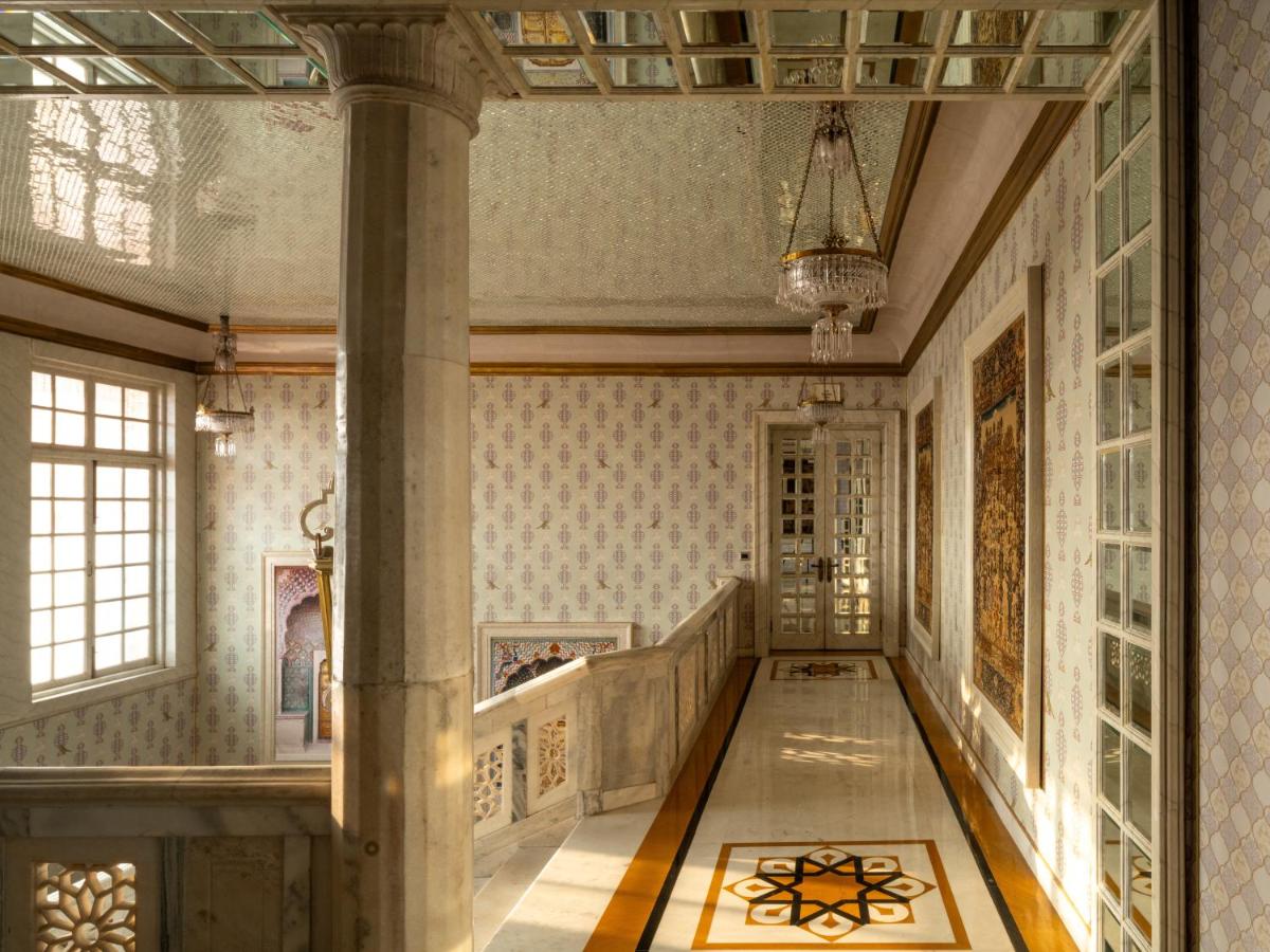 a hallway of a building with a column and a staircase at Rajmahal Palace RAAS in Jaipur