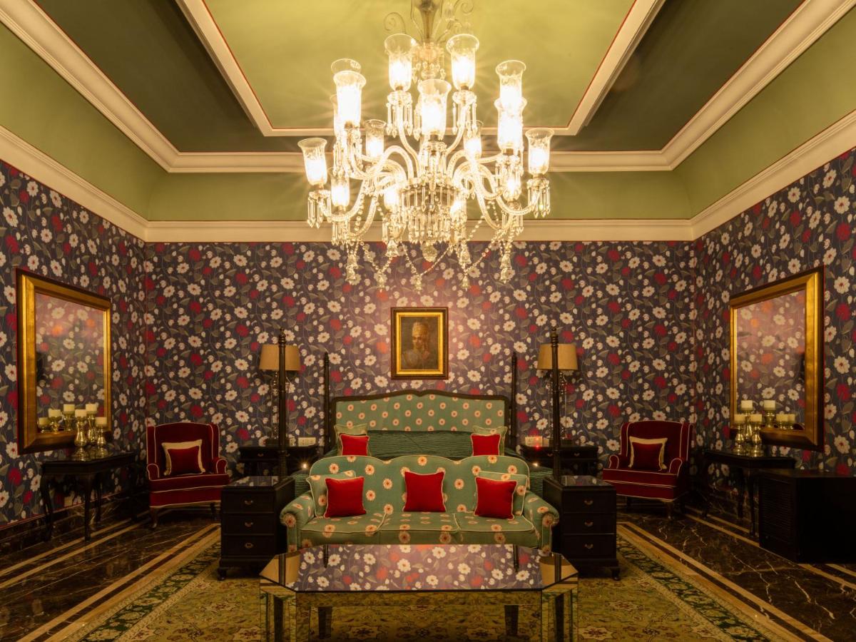 a living room with a couch and a chandelier at Rajmahal Palace RAAS in Jaipur