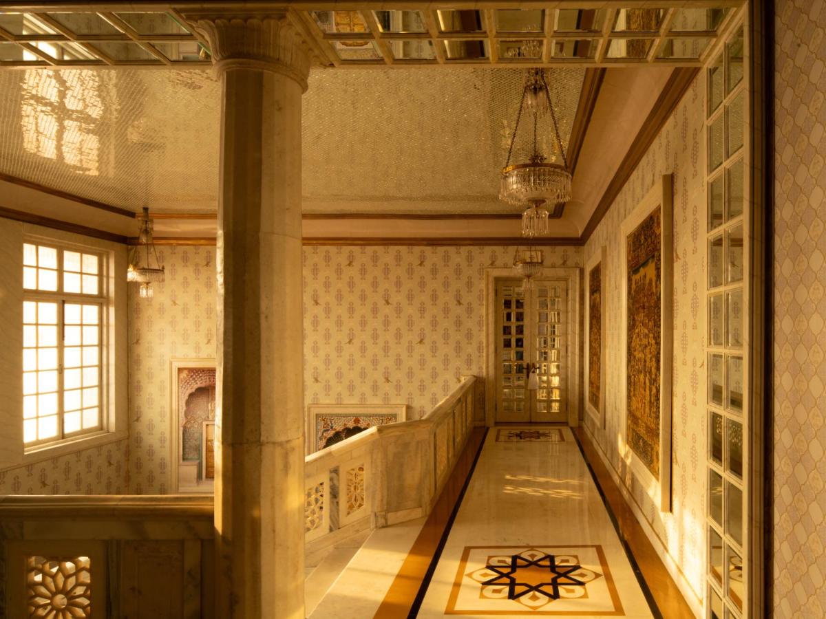 a hallway of a building with a pillar and a staircase at Rajmahal Palace RAAS in Jaipur