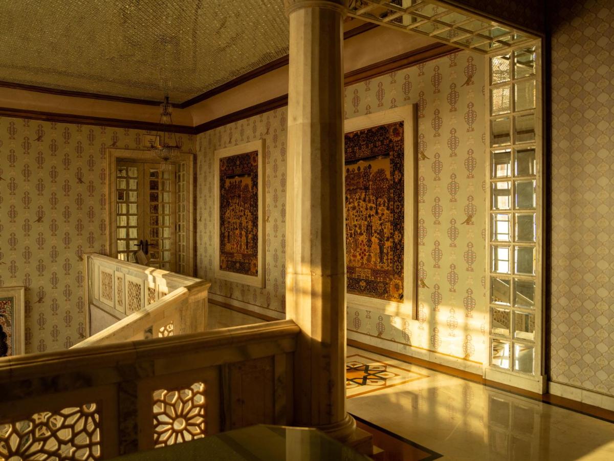 a large room with a pillar and a staircase at Rajmahal Palace RAAS in Jaipur