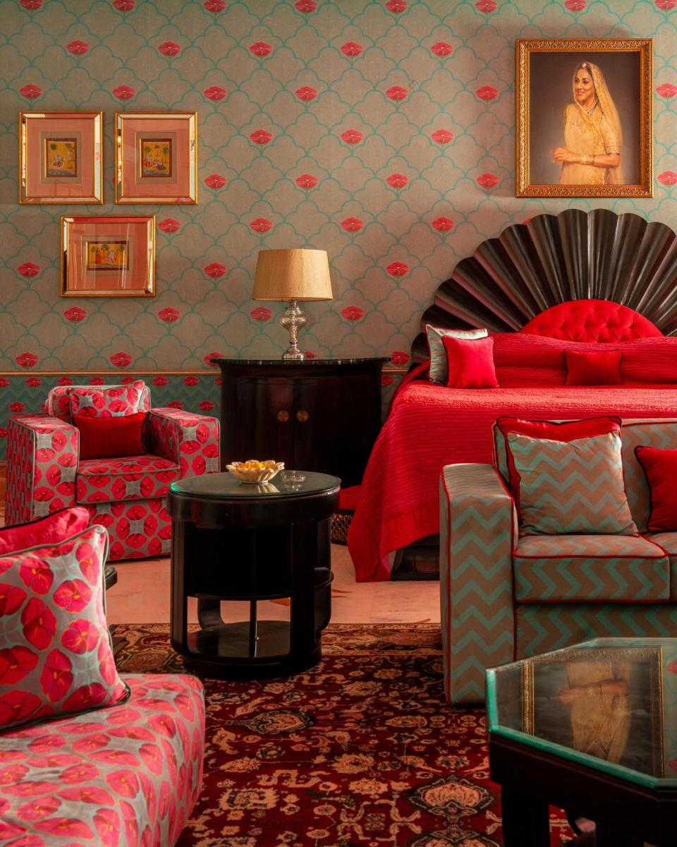 a bedroom with a bed and a couch and a table at Rajmahal Palace RAAS in Jaipur