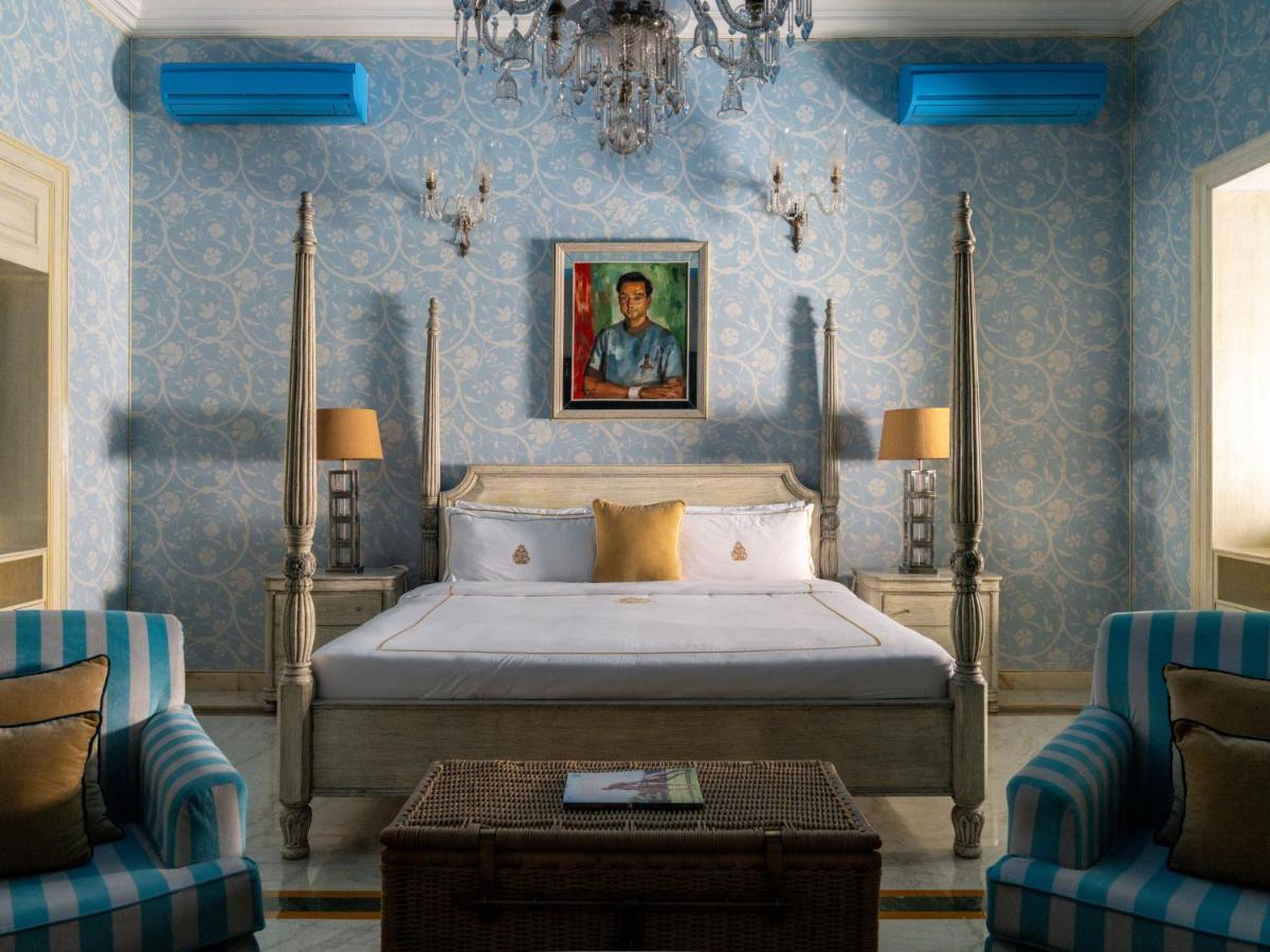 a bedroom with a bed and two chairs at Rajmahal Palace RAAS in Jaipur