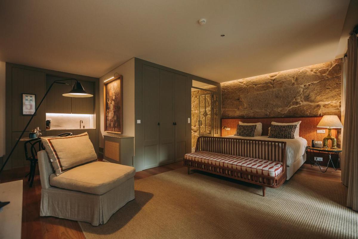 um quarto com uma cama, um sofá e uma cadeira em Torel Saboaria no Porto