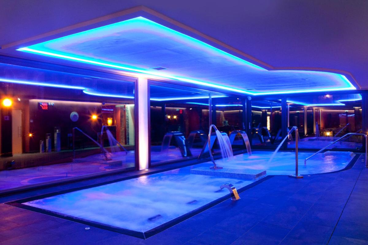 una piscina con un gimnasio con luces azules en Hotel & SPA Peña Montañesa, en Aínsa
