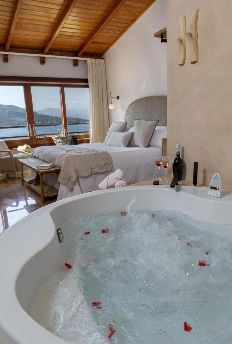 bañera grande en una habitación con 2 camas en Hotel Spa Porto Cristo, en Port de la Selva bañera grande en una habitación con 2 camas en Hotel Spa Porto Cristo, en Port de la Selva