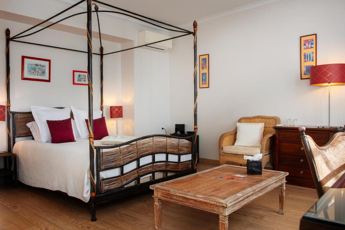 - une chambre avec un lit à baldaquin et une table basse dans l'établissement L'Aubinière Hôtel Restaurant & Spa, à Saint-Ouen-les-Vignes 74 autres photos