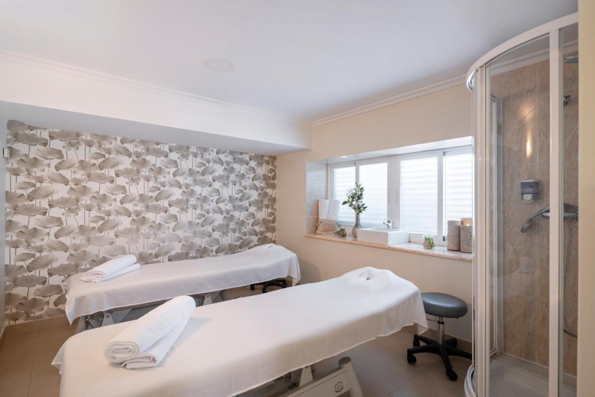 Una habitación de hospital con dos camas y ducha. en Eurostars Louxo Talaso, en Isla de la Toja