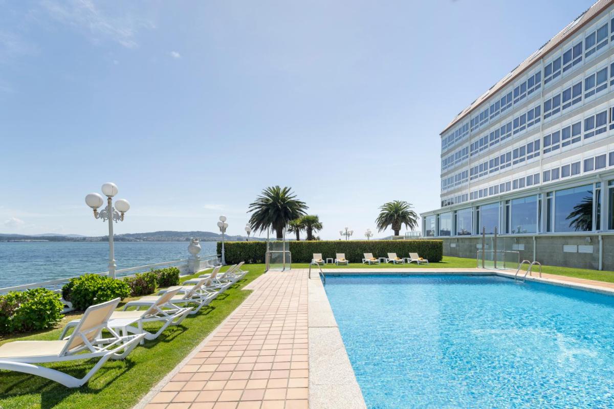 un hotel con piscina al lado de un edificio en Eurostars Louxo Talaso, en Isla de la Toja