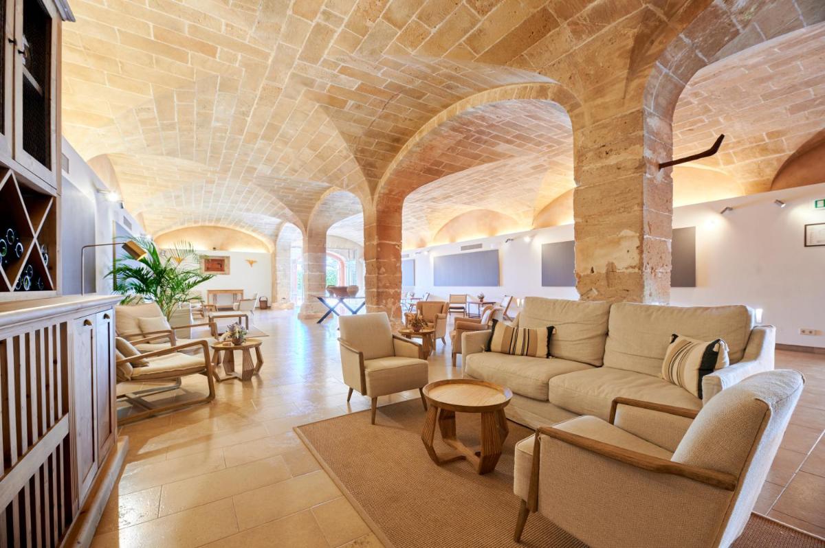 una sala de estar con un sofá y sillas en Zoetry Mallorca Wellness & Spa, en Llucmajor