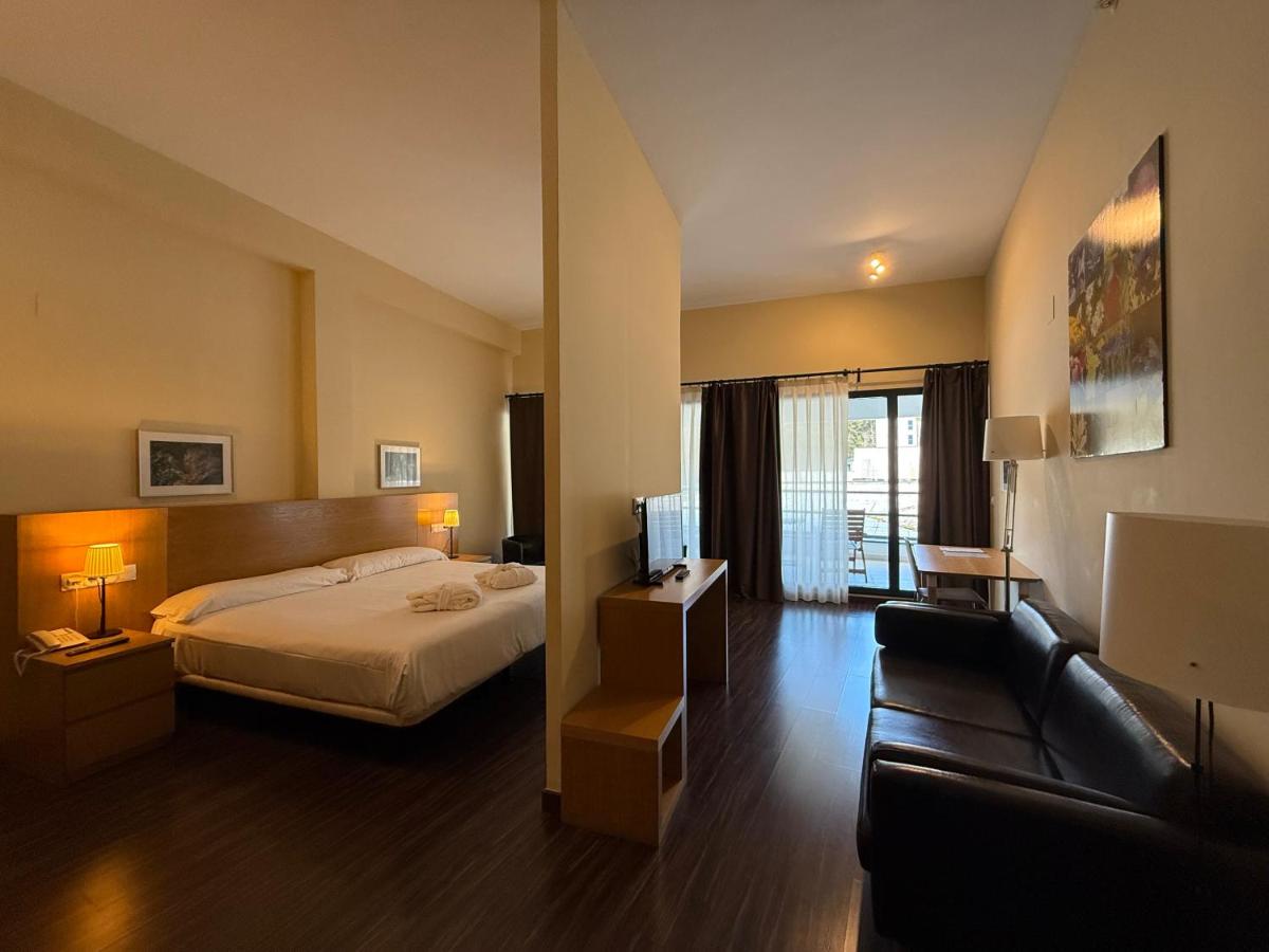 una habitación de hotel con una cama y un sofá en Hotel Balneario de Lanjarón, en Lanjarón