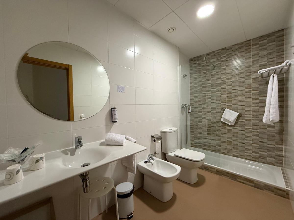 Un baño con lavabo, inodoro y espejo. en Hotel Balneario de Lanjarón, en Lanjarón