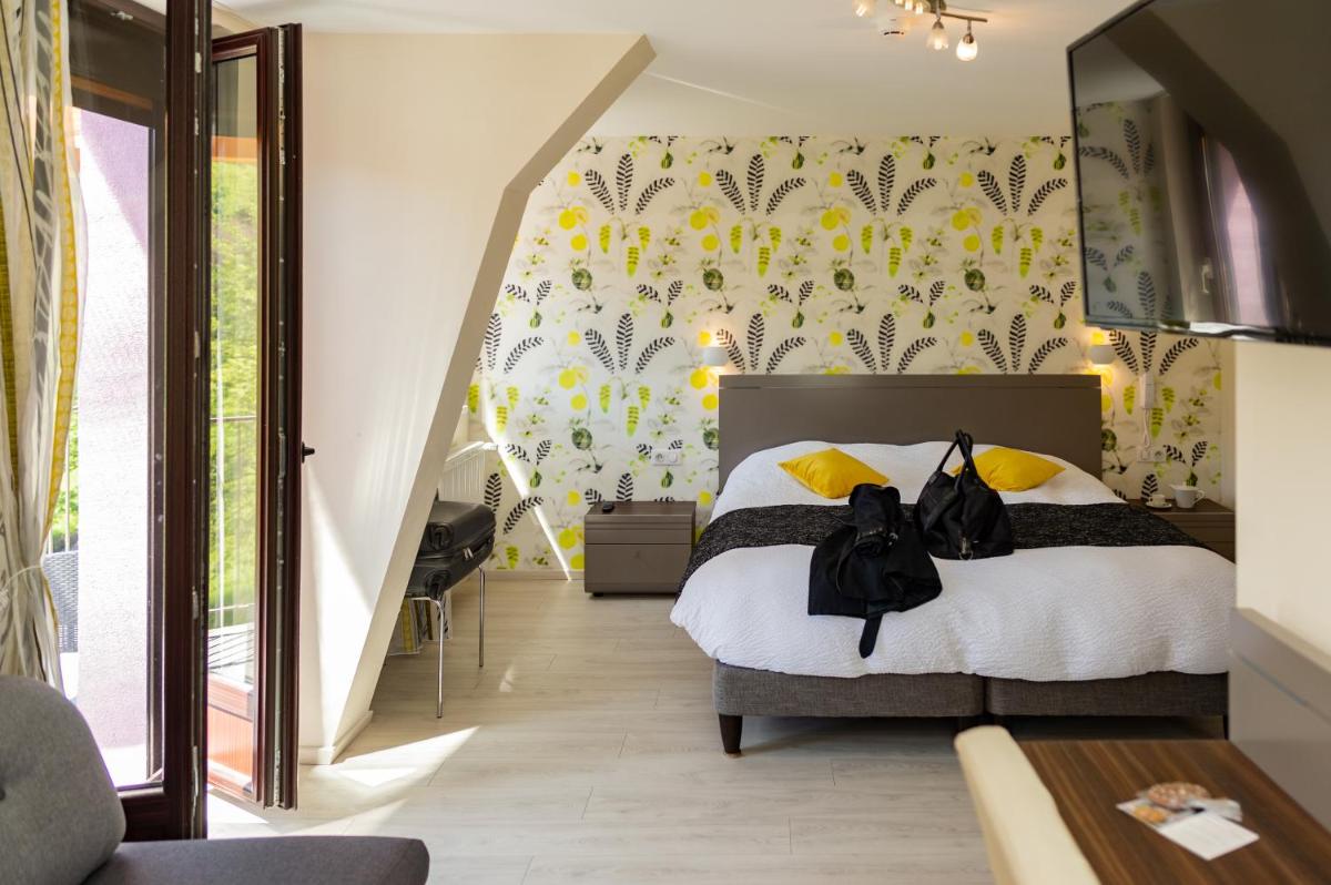 une chambre avec un lit avec un papier peint jaune et blanc dans l'établissement Logis Hotel Des Vosges, à Sewen une chambre avec un lit avec un papier peint jaune et blanc dans l'établissement Logis Hotel Des Vosges, à Sewen