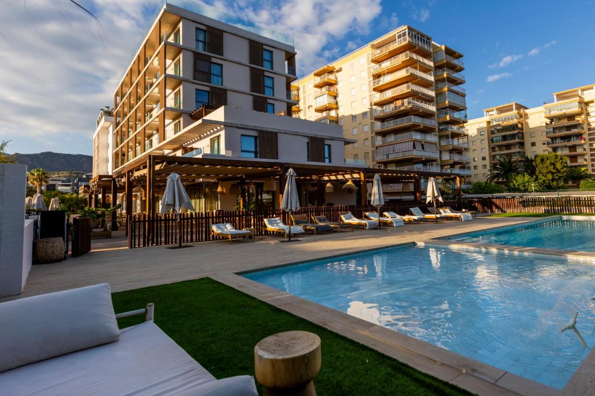 Una piscina con sillas y un edificio. en Albades Hotel & Spa - Adults Only - 4 Star Superior, en Benicàssim