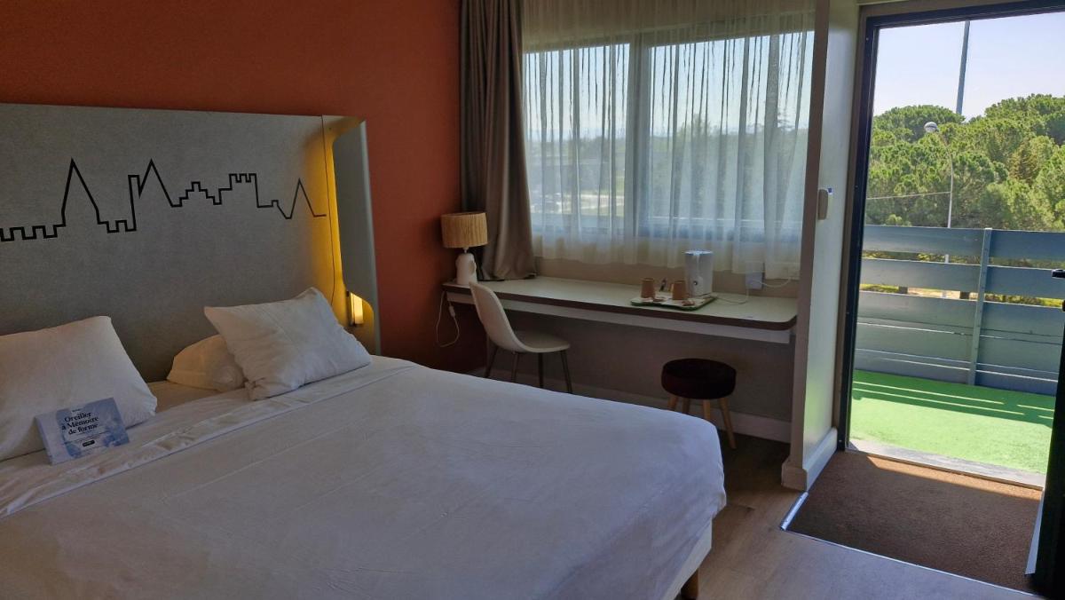 Un ou plusieurs lits dans un hébergement de l'établissement Kyriad Carcassonne - Aéroport
