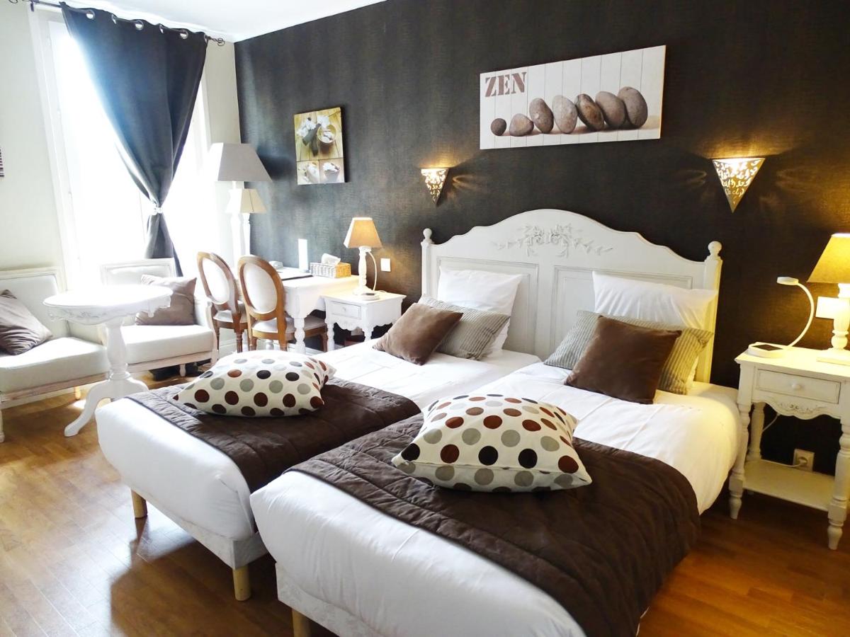 une chambre avec deux lits avec des oreillers dessus dans l'établissement Logis Hôtel Restaurant Spa L'auberge Du President, à Cormeilles