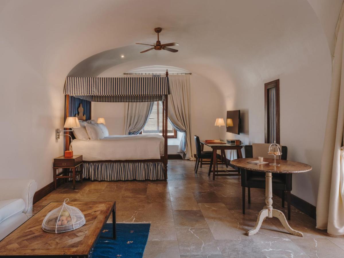 una habitación de hotel con una cama y una mesa en Cap Rocat, a Small Luxury Hotel of the World, en Cala Blava