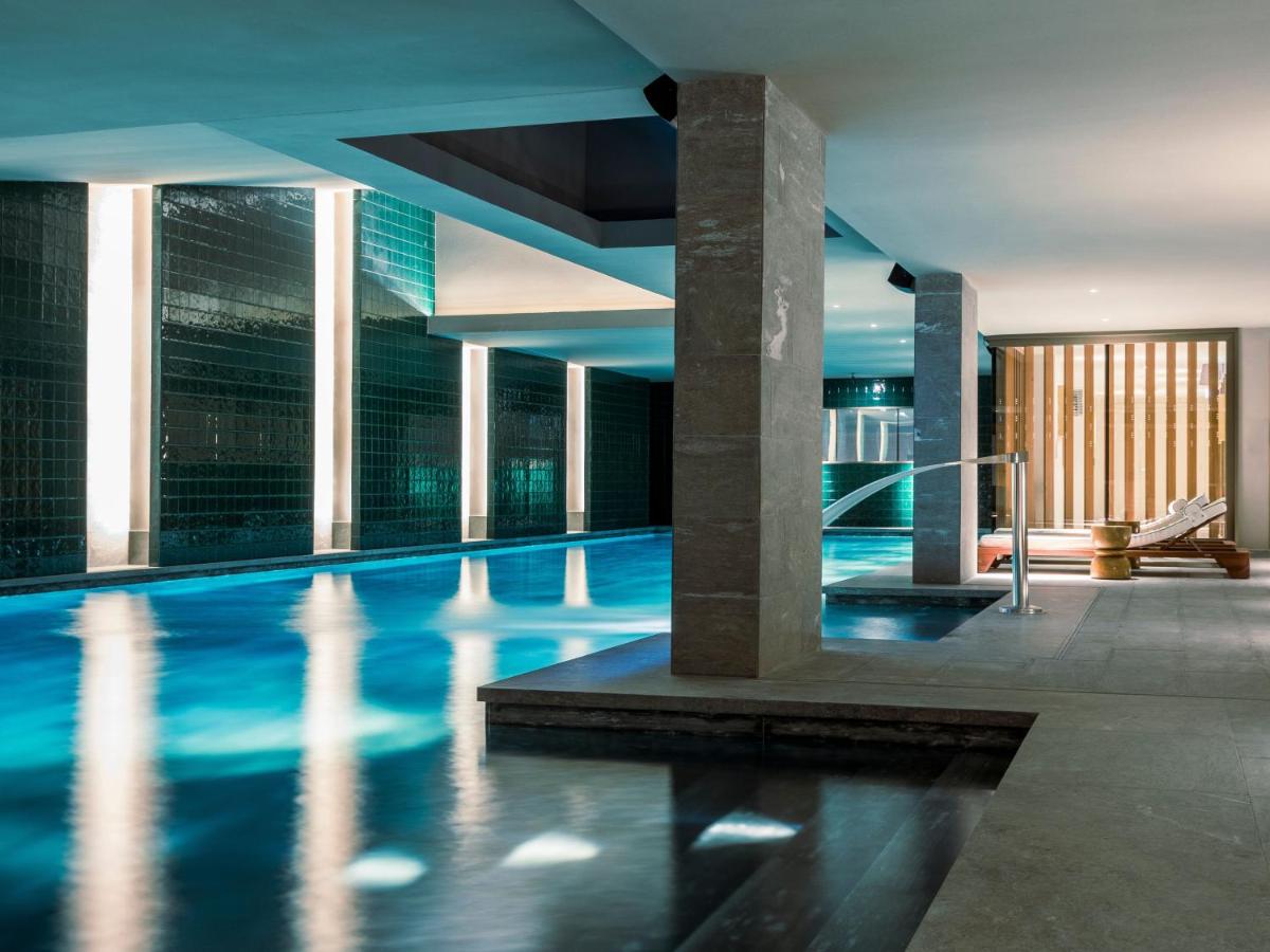 une piscine dans un bâtiment avec de l'eau bleue dans l'établissement La Fondation, à Paris