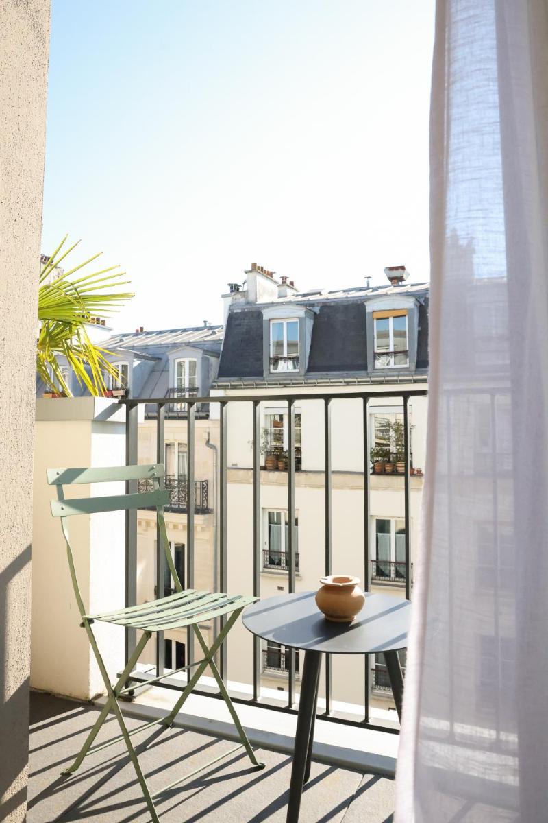 d'un balcon avec une table et une vue sur un bâtiment. dans l'établissement Bloom House Hôtel & SPA, à Paris