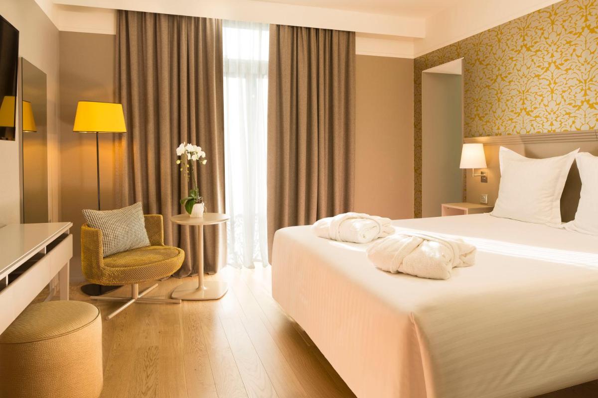une chambre d'hôtel avec un lit et une chaise dans l'établissement Oceania Le Jura Dijon, à Dijon