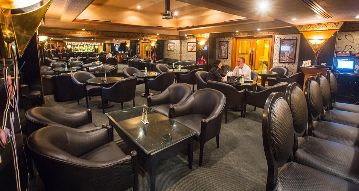 a restaurant with tables and chairs in a room at The Orchid Hotel Mumbai Vile Parle in Mumbai