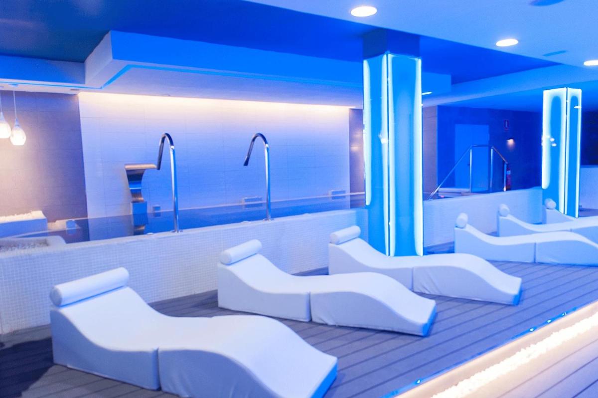 Un baño con sillas blancas y un espejo. en Servatur Casablanca Suites & Spa - Adults Only, en Puerto Rico de Gran Canaria