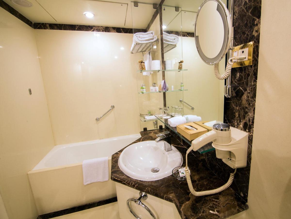 a bathroom with a sink and a bath tub at The Orchid Hotel Mumbai Vile Parle in Mumbai