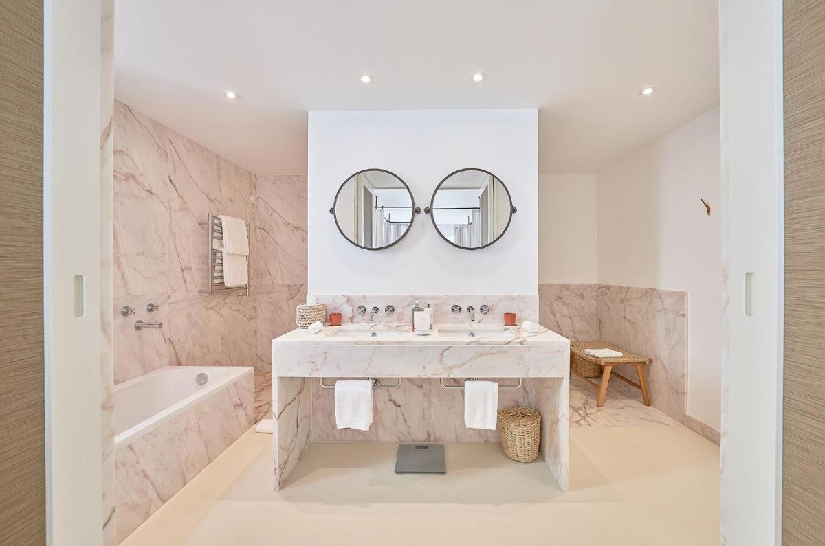 um banheiro com uma pia e dois espelhos em Praia do Canal Nature Retreat - Small Luxury Hotels of the World em Aljezur