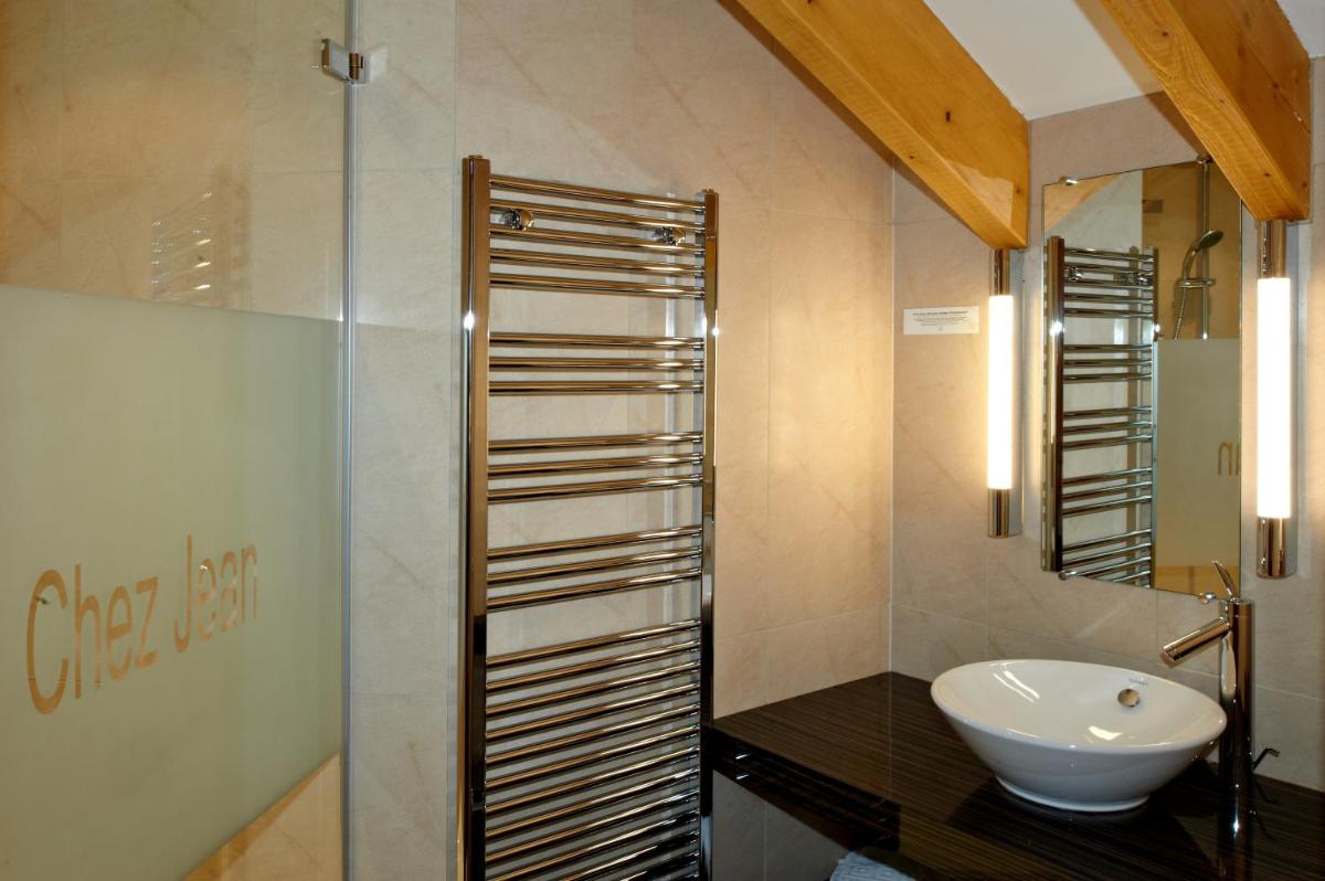 une salle de bain avec un lavabo et une douche en verre dans l'établissement Chez Jean, à Saverne 19 autres photos