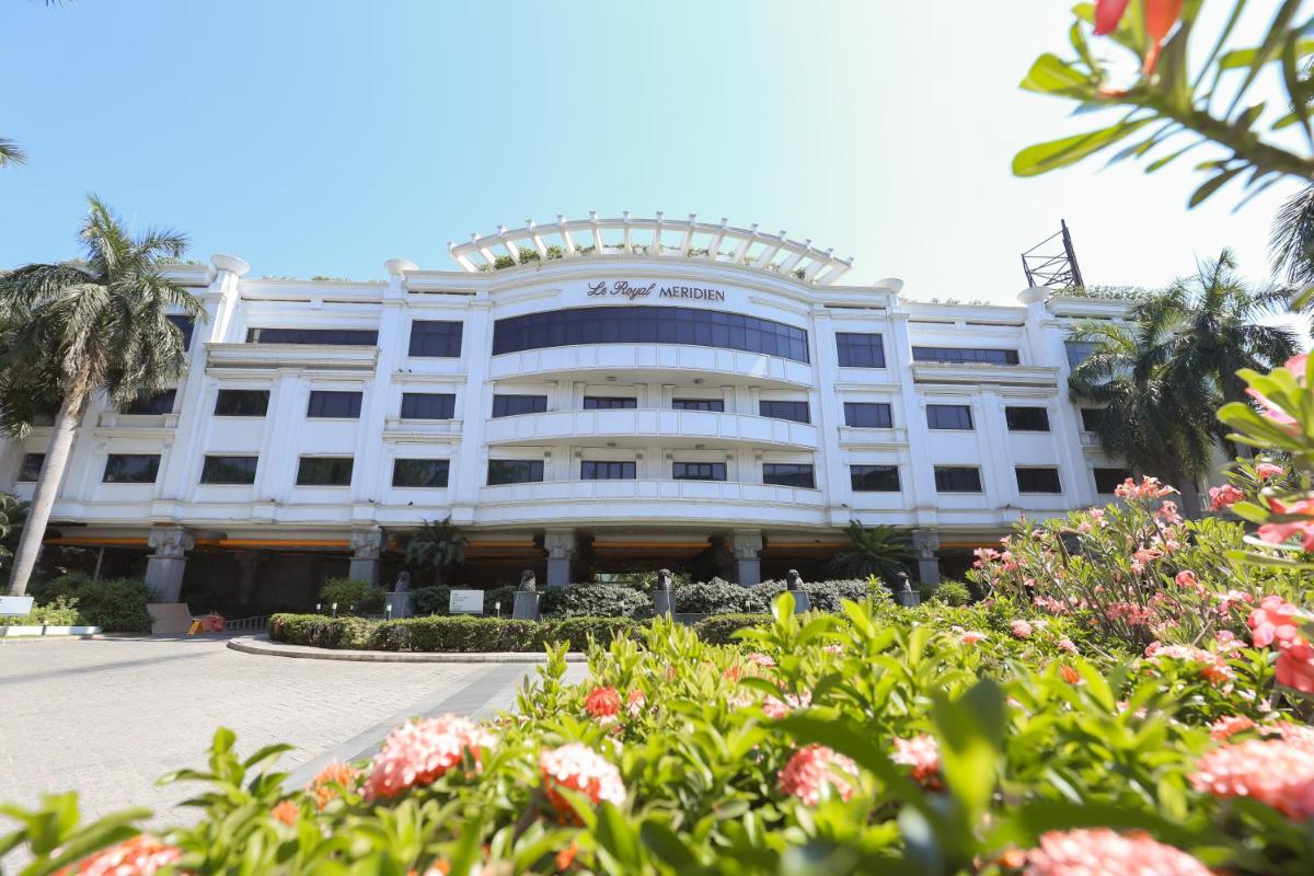 a large white building with flowers in front of it at Le Royal Meridien Chennai in Chennai