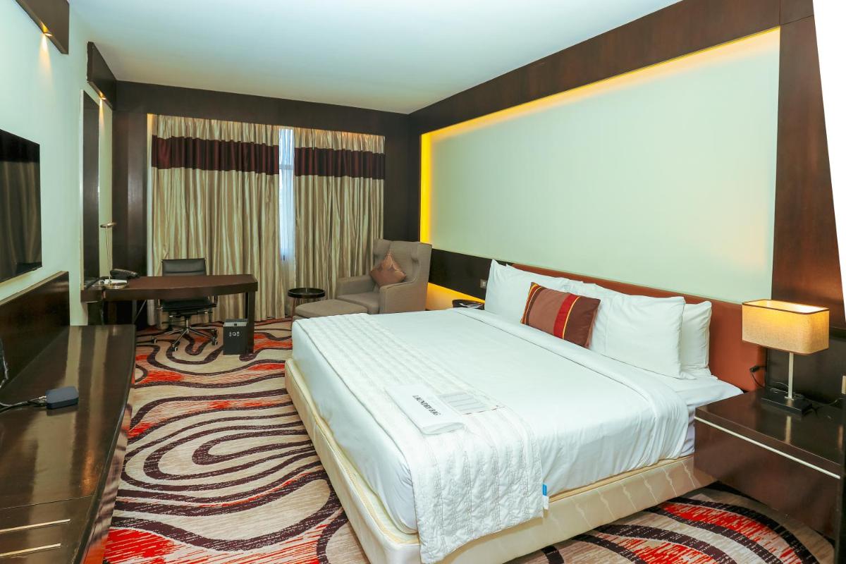 a hotel room with a large bed and a desk at Le Royal Meridien Chennai in Chennai