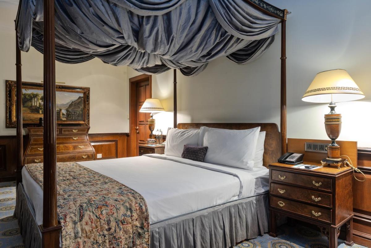 a bedroom with a canopy bed and a dresser at Le Royal Meridien Chennai in Chennai