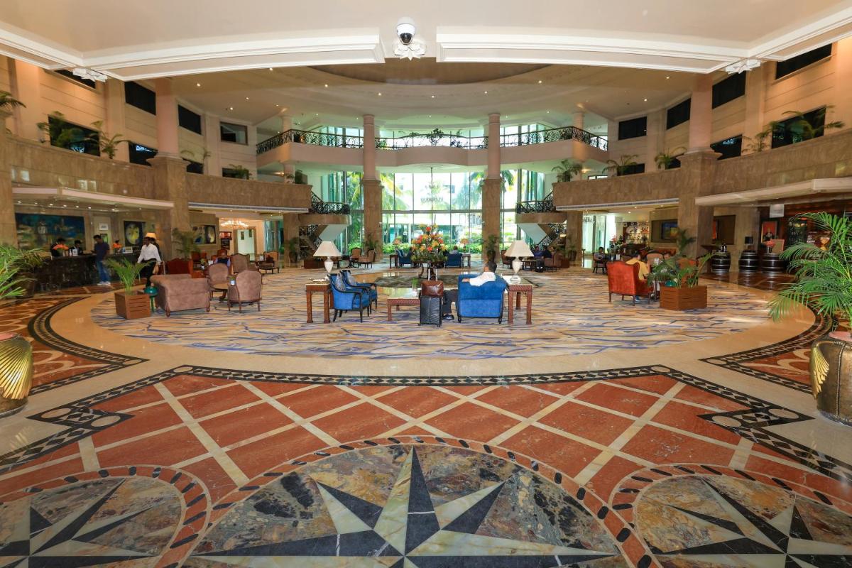 a lobby with chairs and tables in a building at Le Royal Meridien Chennai in Chennai