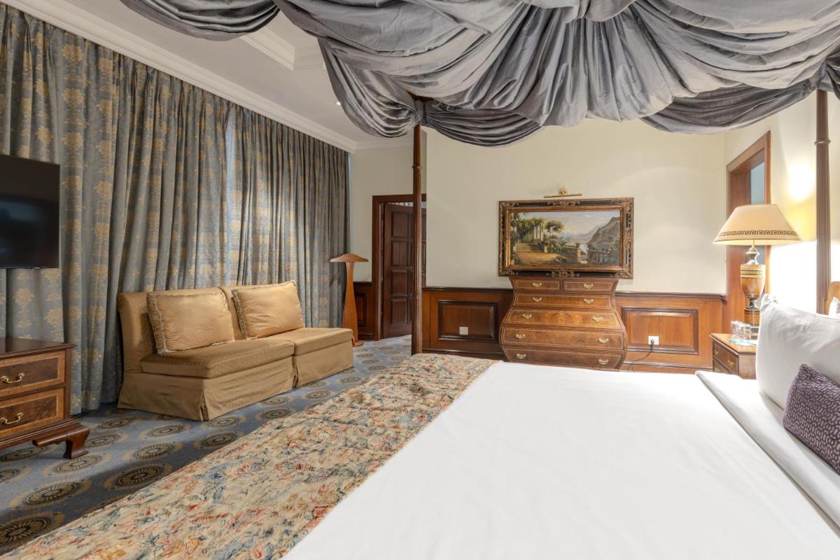 a hotel room with a bed and a couch at Le Royal Meridien Chennai in Chennai