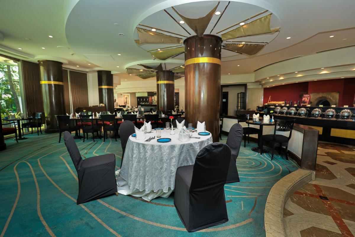 a dining room with a table and chairs at Le Royal Meridien Chennai in Chennai