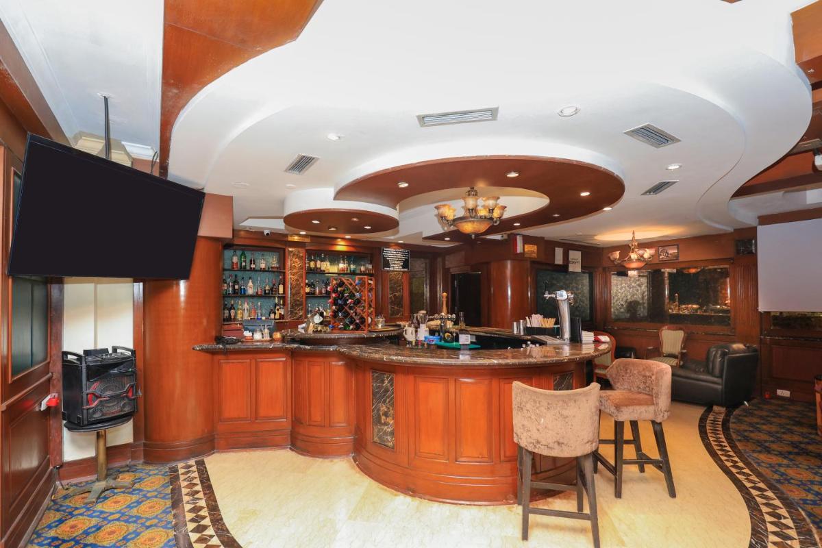 a bar in a room with a tv and a bar counter at Le Royal Meridien Chennai in Chennai