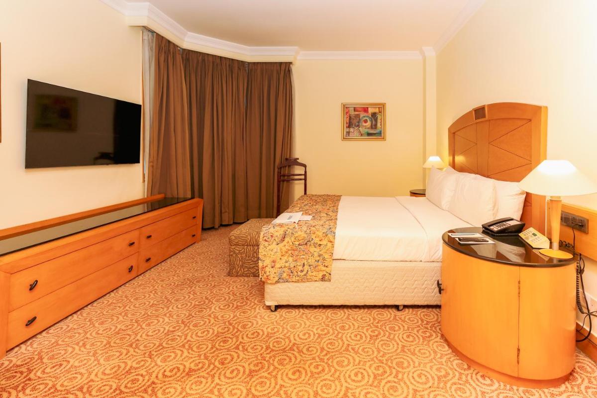 a hotel room with a bed and a television at Le Royal Meridien Chennai in Chennai