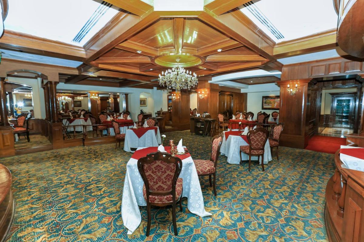 a restaurant with tables and chairs in a room at Le Royal Meridien Chennai in Chennai
