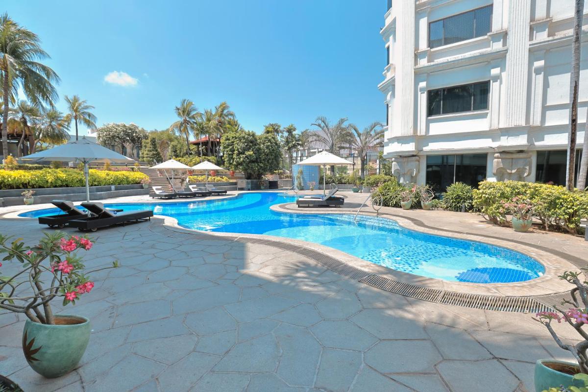 a swimming pool in front of a building at Le Royal Meridien Chennai in Chennai