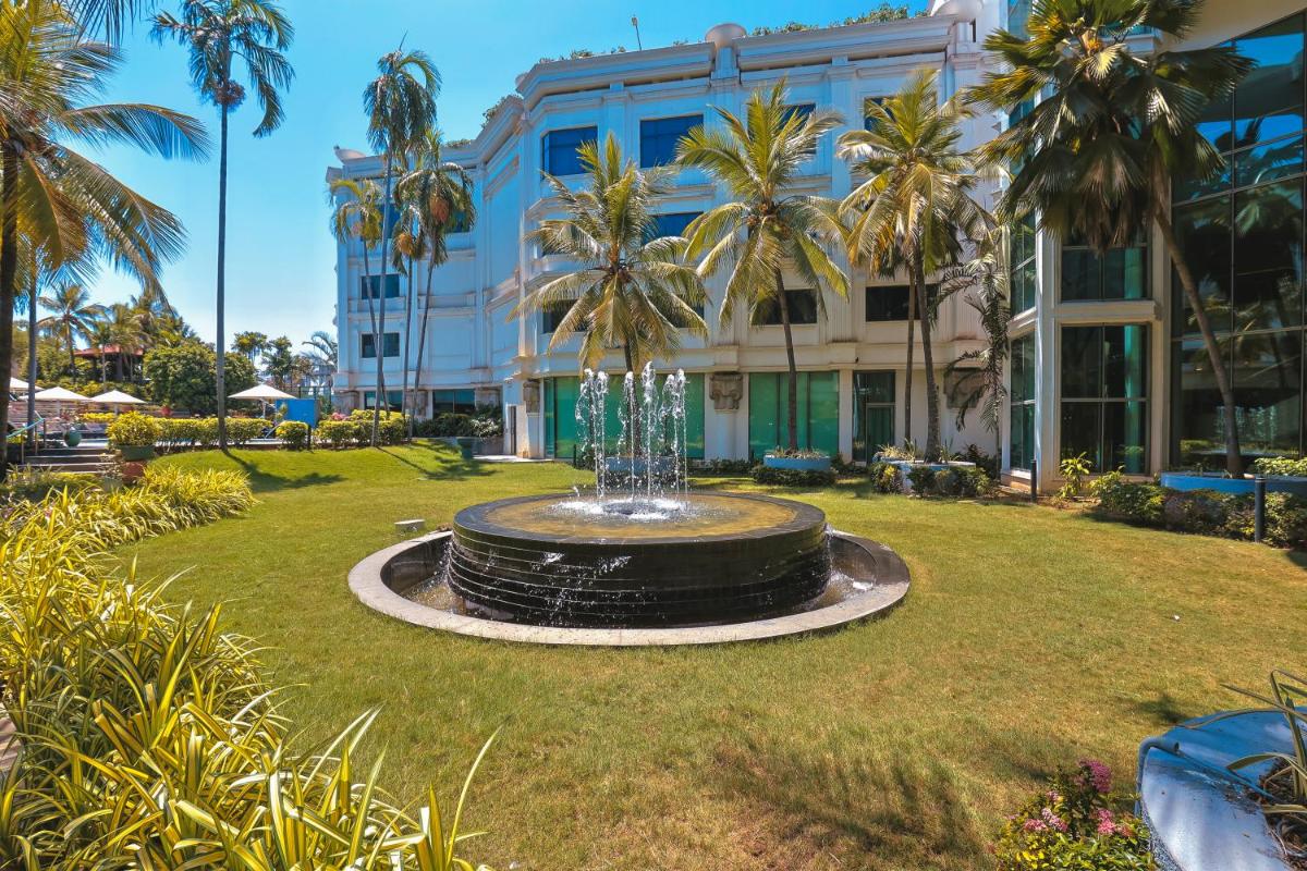 a fountain in a park in front of a building at Le Royal Meridien Chennai in Chennai