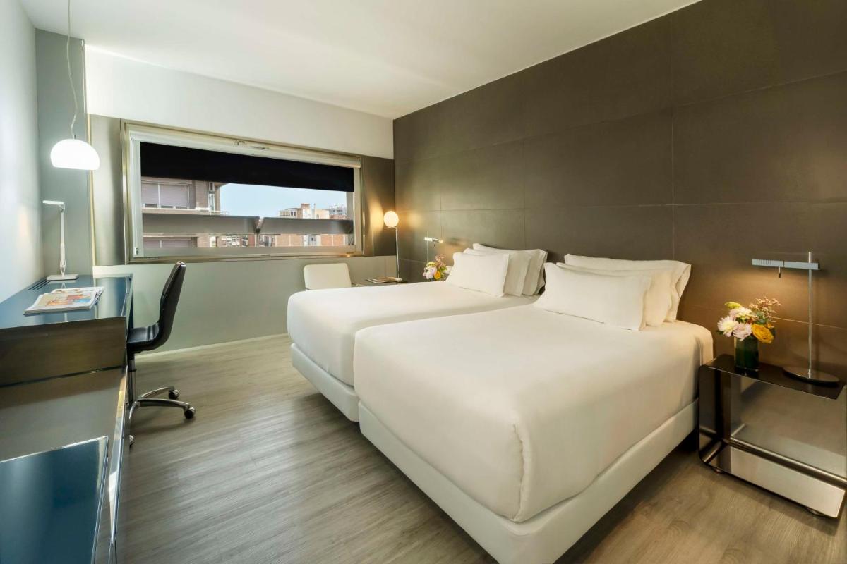 Una habitación de hotel con dos camas y una ventana. en NH Collection Barcelona Constanza, en Barcelona