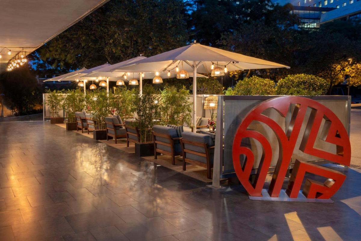 Un restaurante con mesas y sillas y una sombrilla. en NH Collection Barcelona Constanza, en Barcelona 45 fotos más