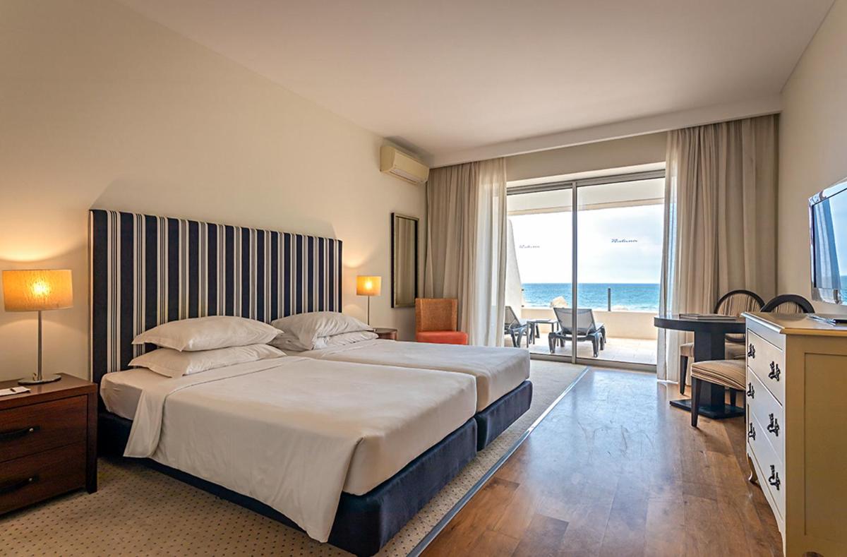um quarto de hotel com uma cama e vista para o oceano em Pestana Alvor Praia Premium Beach & Golf Resort em Alvor mais 111 fotografias