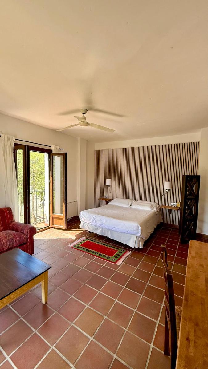 Un dormitorio con una cama y una sala de estar. en Cerro de Hijar, en Tolox 51 fotos más