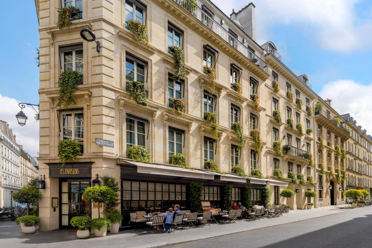 un grand bâtiment avec des gens assis à l'extérieur dans l'établissement Pavillon Faubourg Saint-Germain & Spa, à Paris