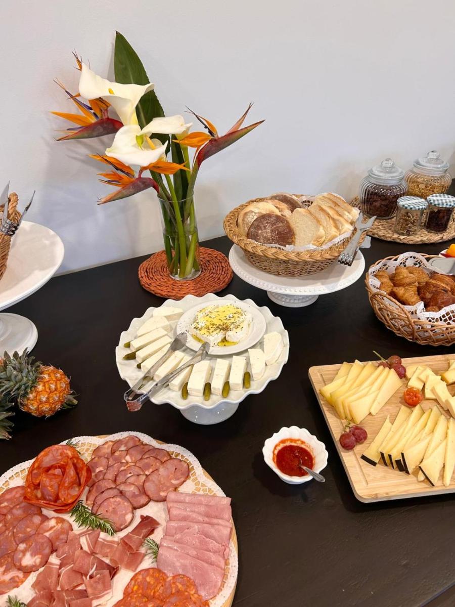 uma mesa coberta com muitos tipos diferentes de comida em Azores Homes Resort & Spa em Ponta Delgada