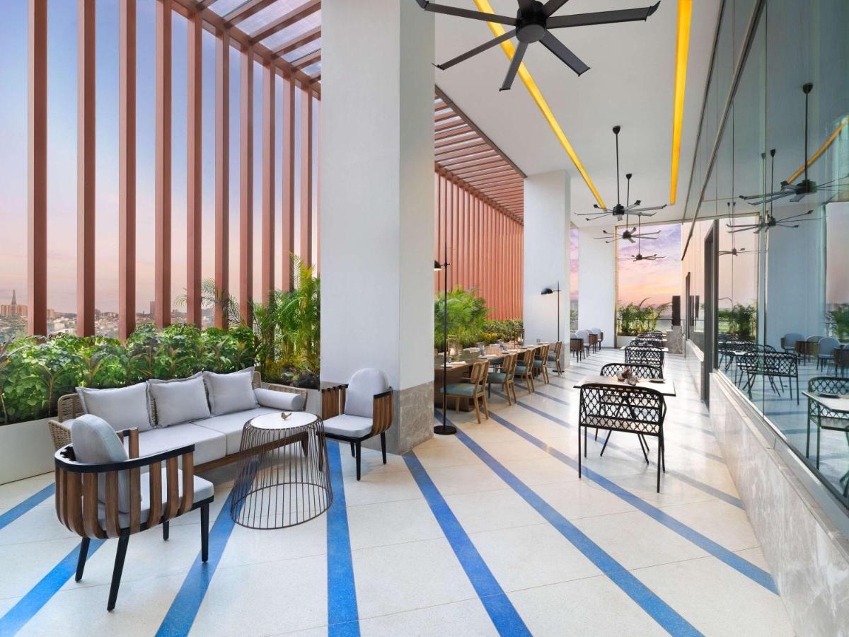 a lobby with a couch and tables and chairs at Novotel New Delhi City Centre in New Delhi a lobby with a couch and tables and chairs at Novotel New Delhi City Centre in New Delhi