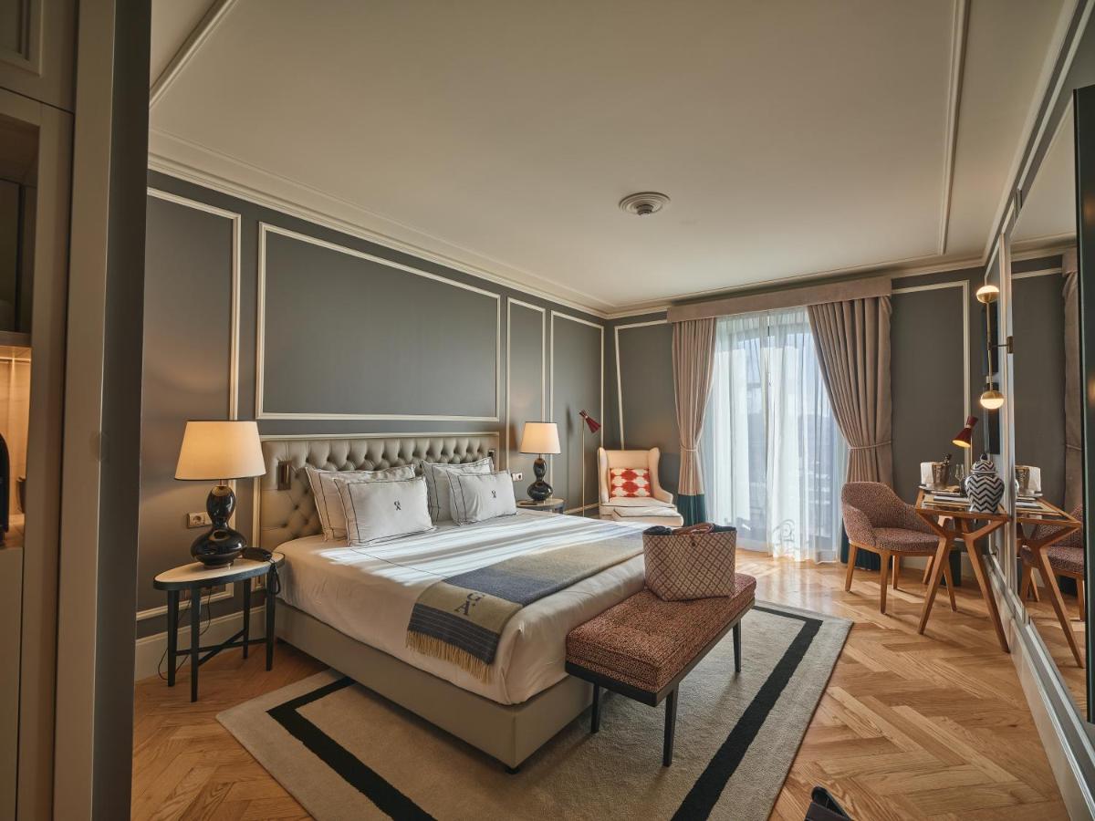 um quarto com uma cama grande, uma mesa e cadeiras em GA Palace Hotel & Spa, a XIXth-Century Villa no Porto mais 194 fotografias