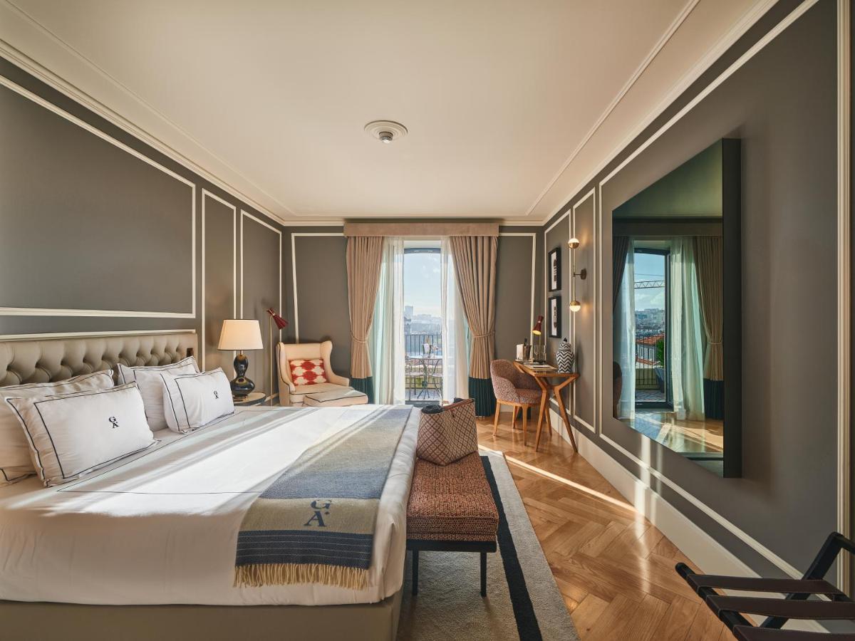 um quarto com uma cama grande e uma escrivaninha em GA Palace Hotel & Spa, a XIXth-Century Villa no Porto